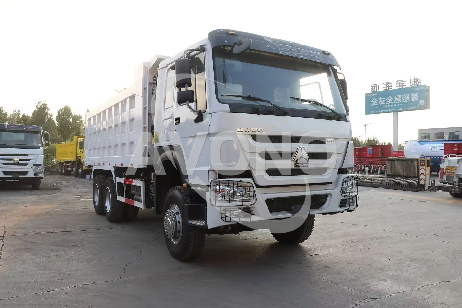 White refurbished HOWO-7 dump truck, side and front view in the yard