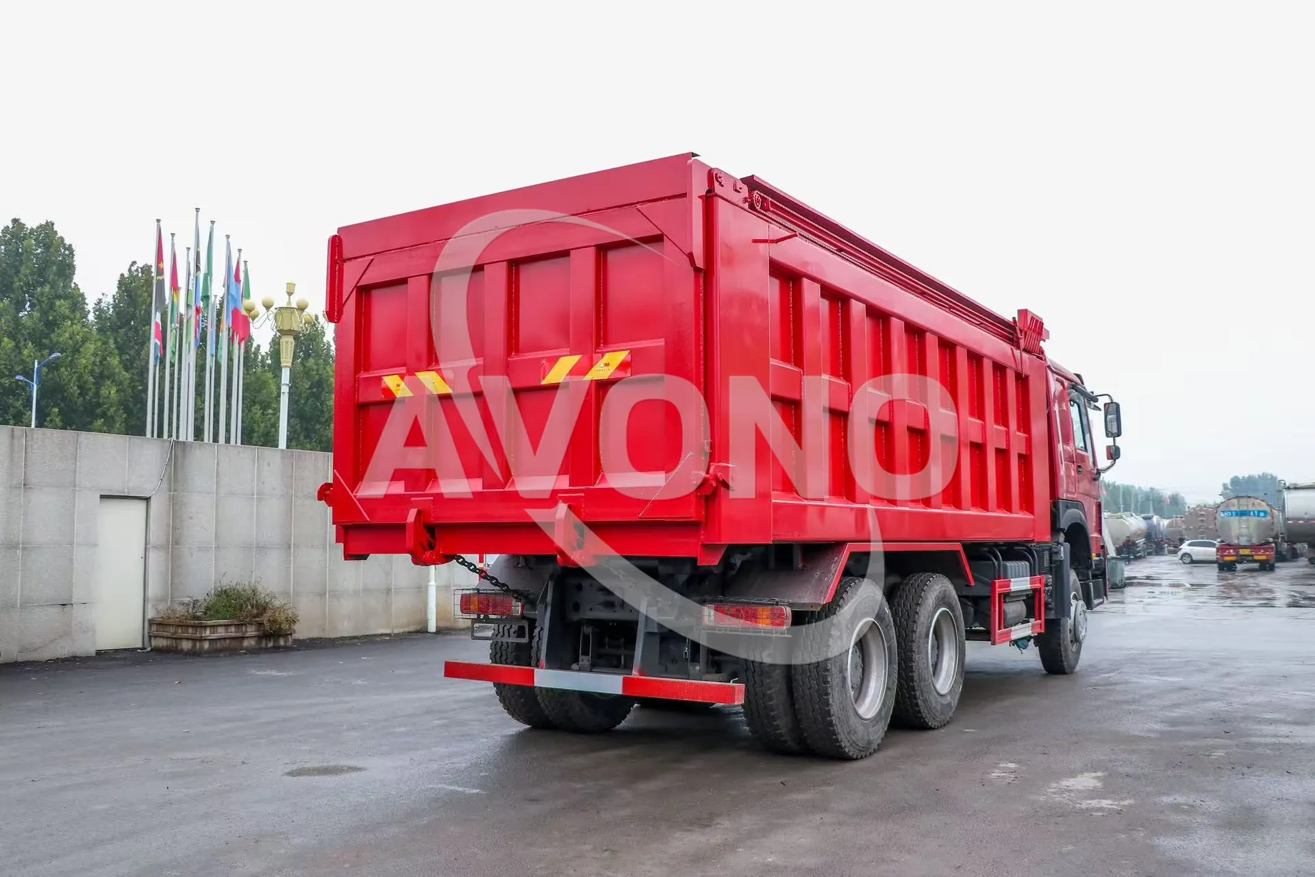Red refurbished HOWO dump truck, rear three-quarter view with tailgate