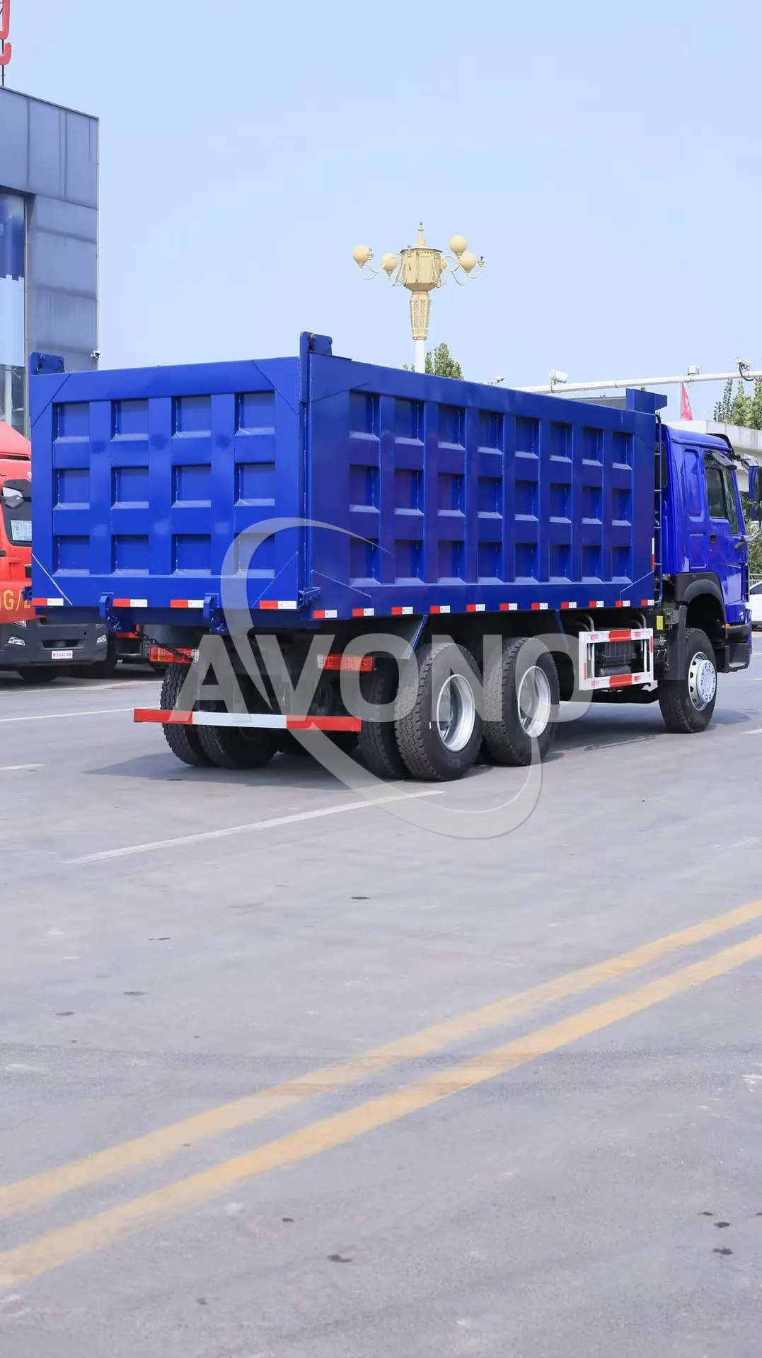 Blue refurbished HOWO tipper truck driving out of the export yard